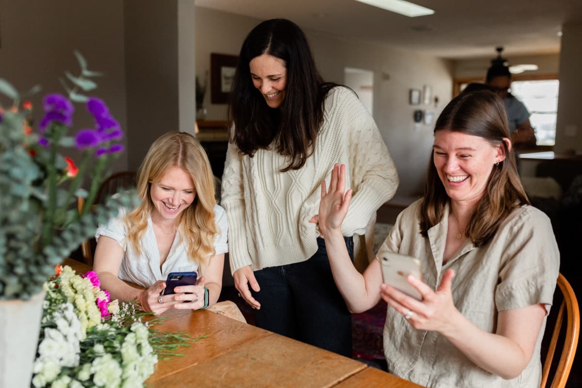 Friends laughing and sharing on their phones