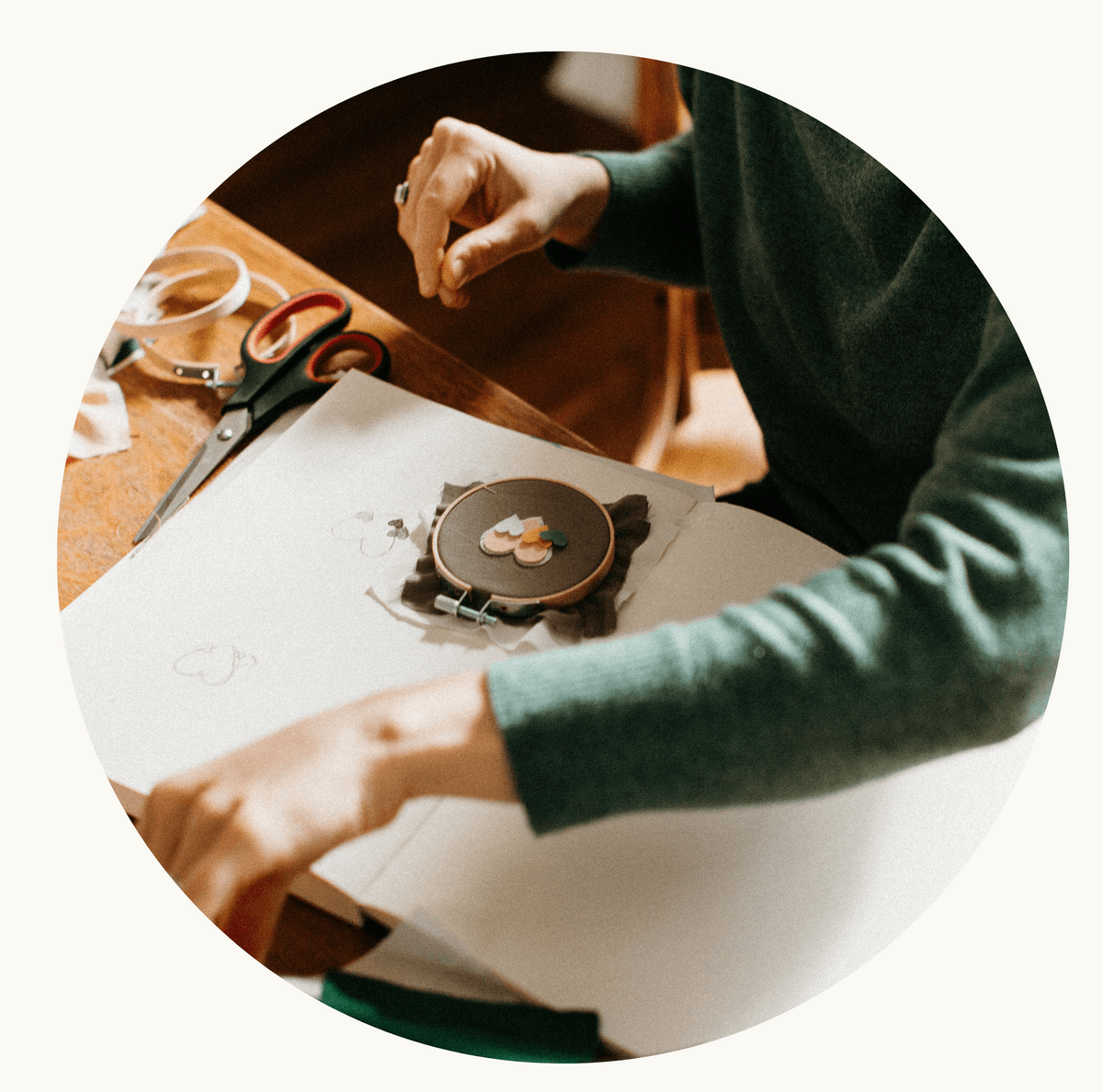 Hand embroidering a badge with needle and thread